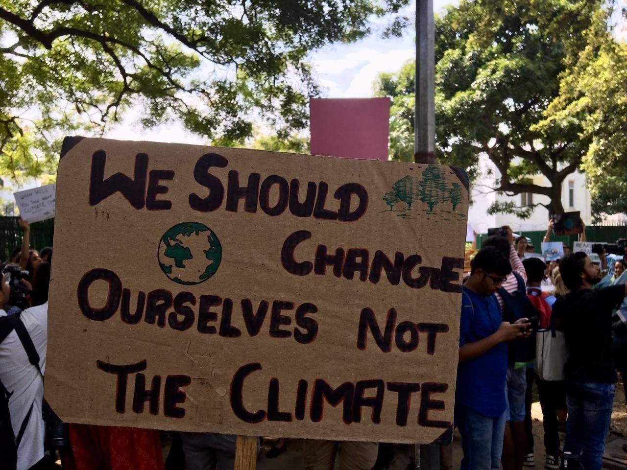 sign that reads &quot;we should change ourselfs not the climate&quot;